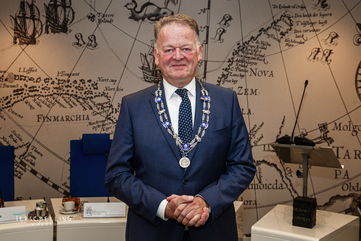 Foto van de tijdelijke burgemeester van Terschelling in opdracht van / voor de gemeente Terschelling. "Onze tijdelijke burgemeester en de raad voor de lens voor dat de vergadering begint."