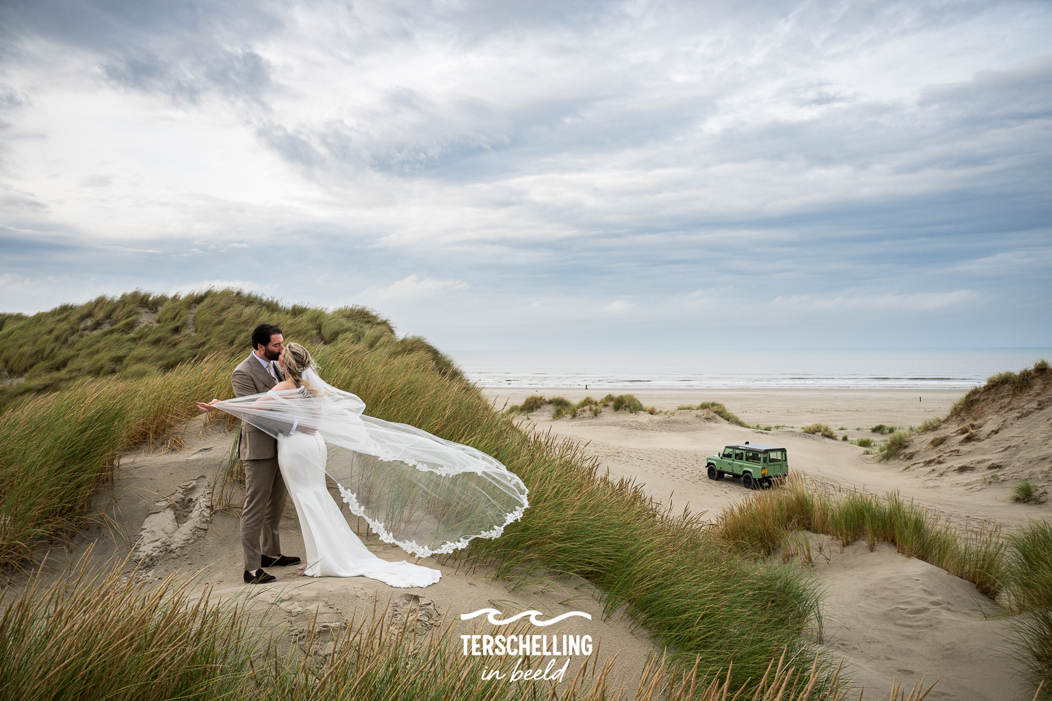 Trouwfotograaf Terschelling met een fotoshoot op het strand met een defender landrover 
